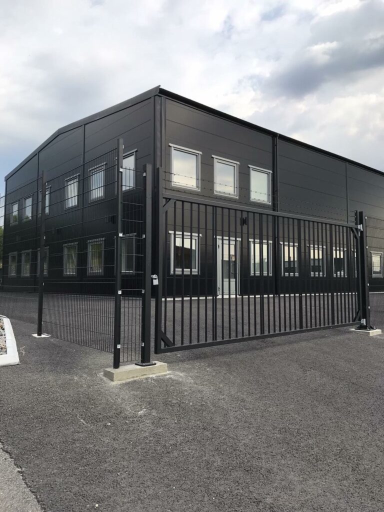 En svart grind som stänger av ingen till ett företag.