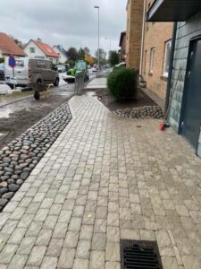 Färdig stenläggning som visar en stenlagd entré utanför en byggnad