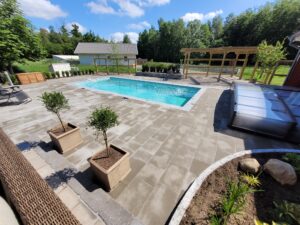 Färdig stenläggning som visar en stor stenlagd uteplats med pool